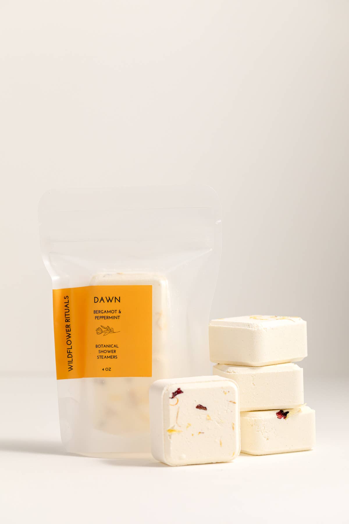 Packaged shower steamers with a yellow label on a white background