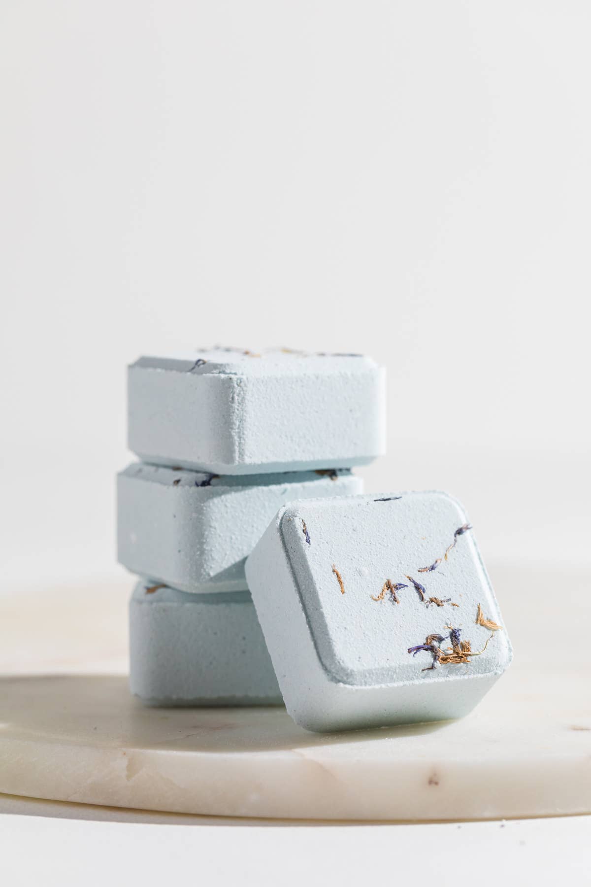 Stack of light blue soap bars with floral design on a white background