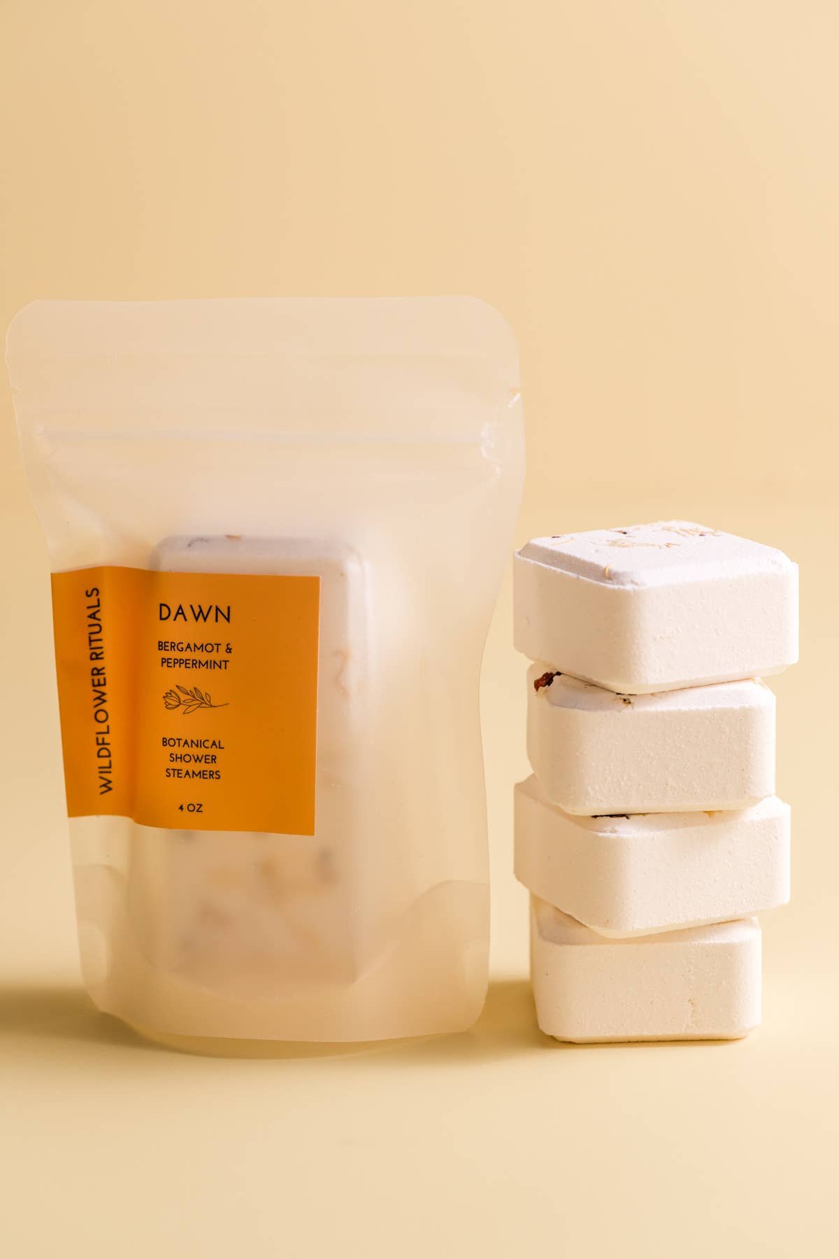 Packaged shower steamers with a label on a beige background
