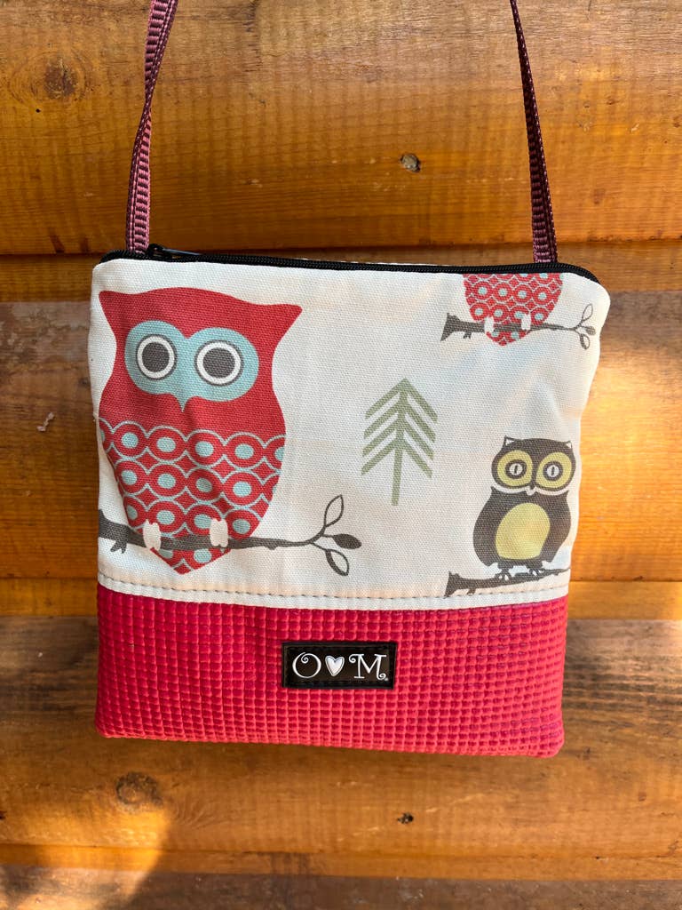 Small purse with owl design on a wooden surface