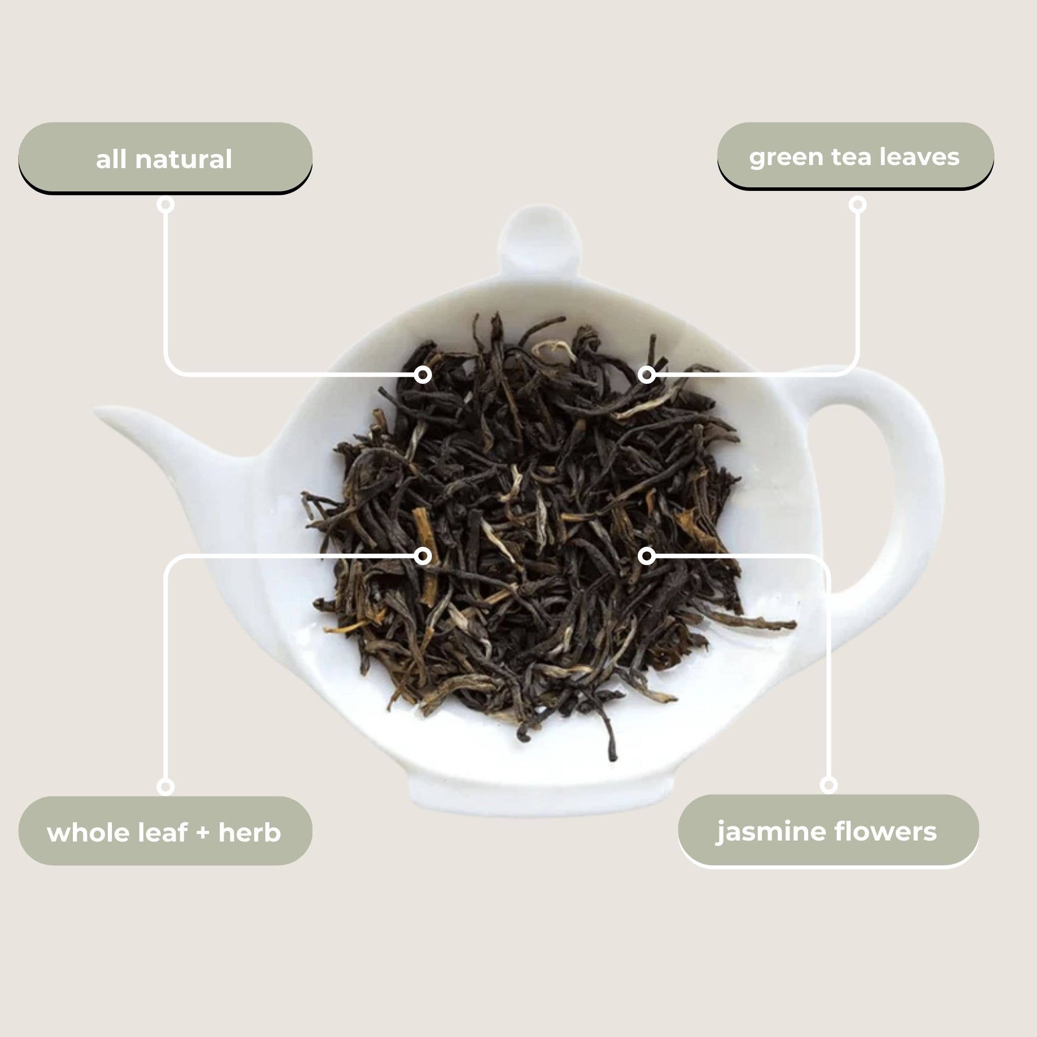 White teapot with green tea leaves, whole leaf + herb, and jasmine flowers on a beige background.
