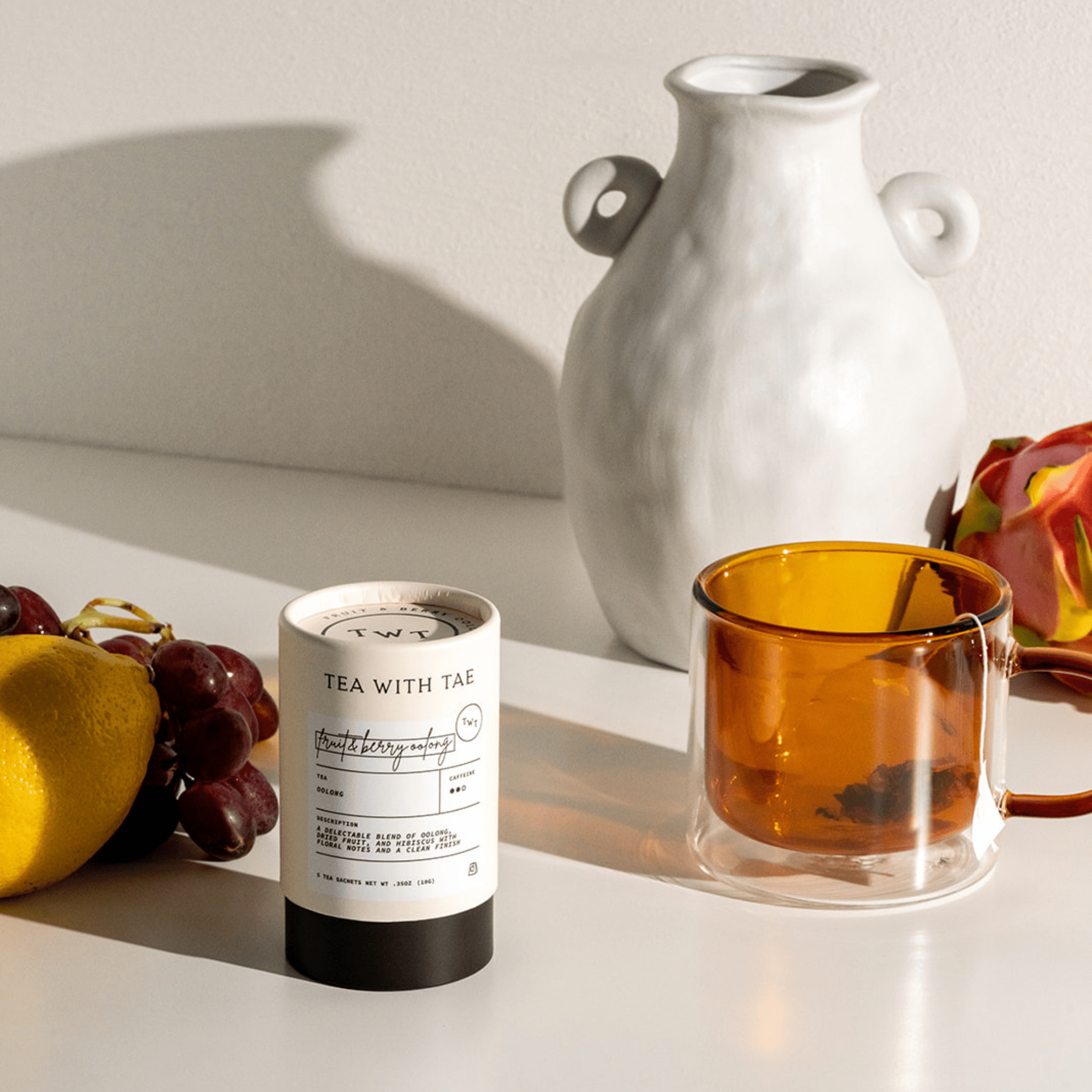 Tea packaging with a cup of tea and fruits on a light surface
