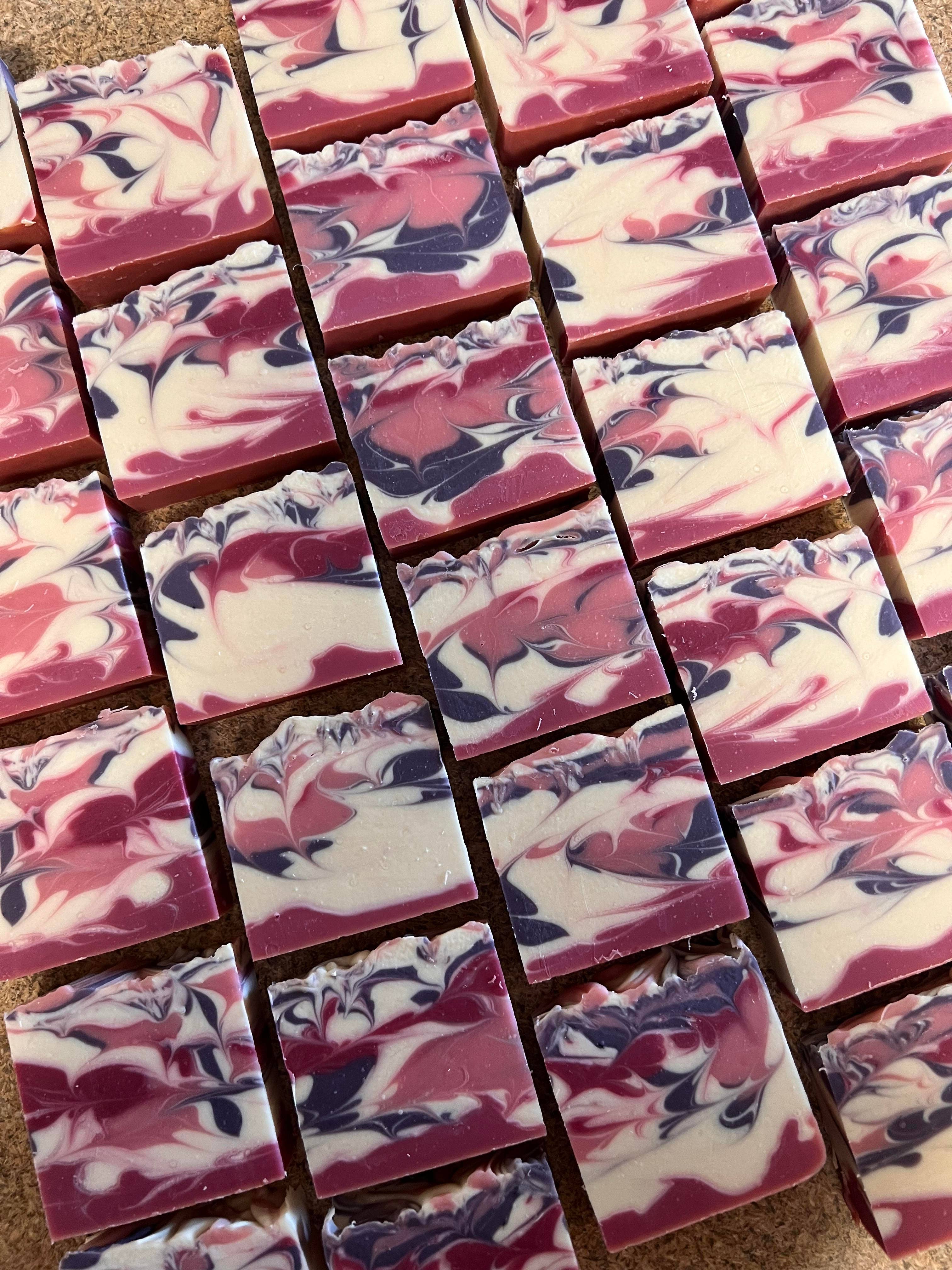Marbled pink, purple, and white soap bars arranged in rows.