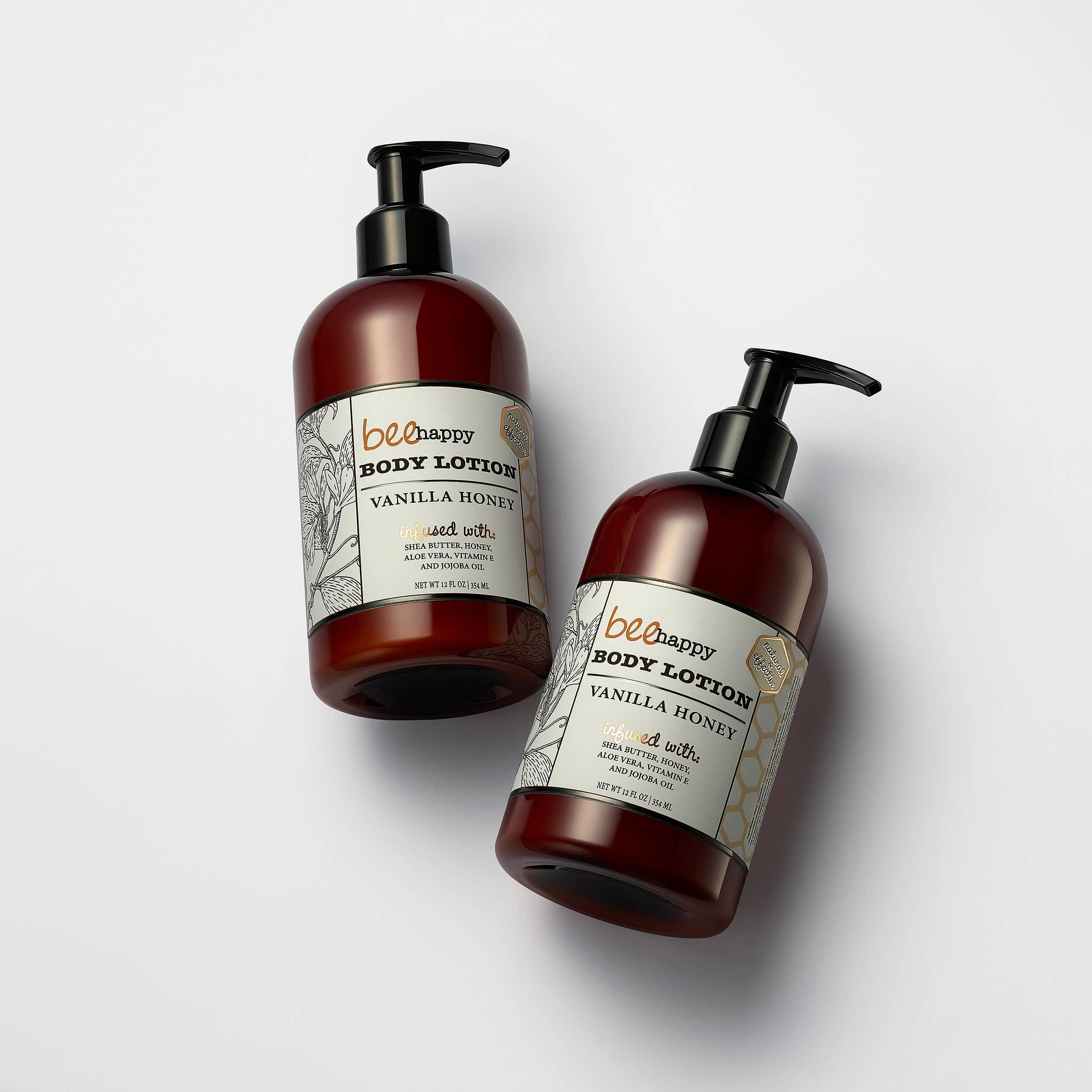 Two bottles of bee happy body lotion with pump dispensers on a white background
