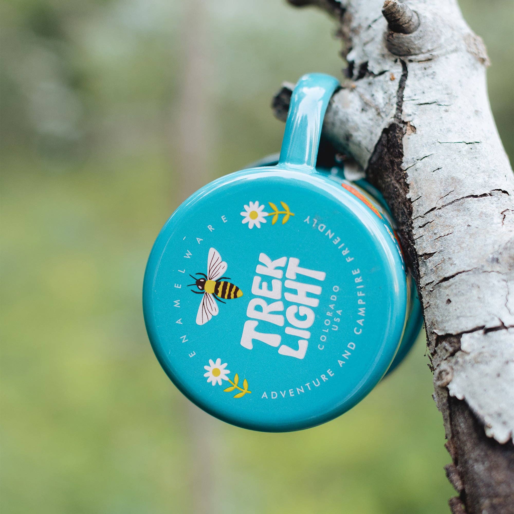 Trek Light teal coffee cup bottom with bee illustration on a tree branch