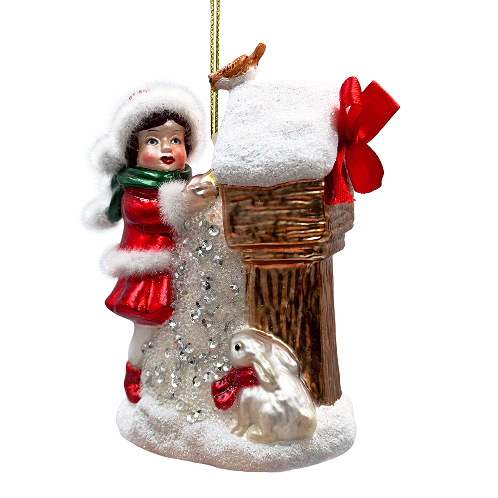 Christmas ornament of a girl with a rabbit and snow-covered house on a white background