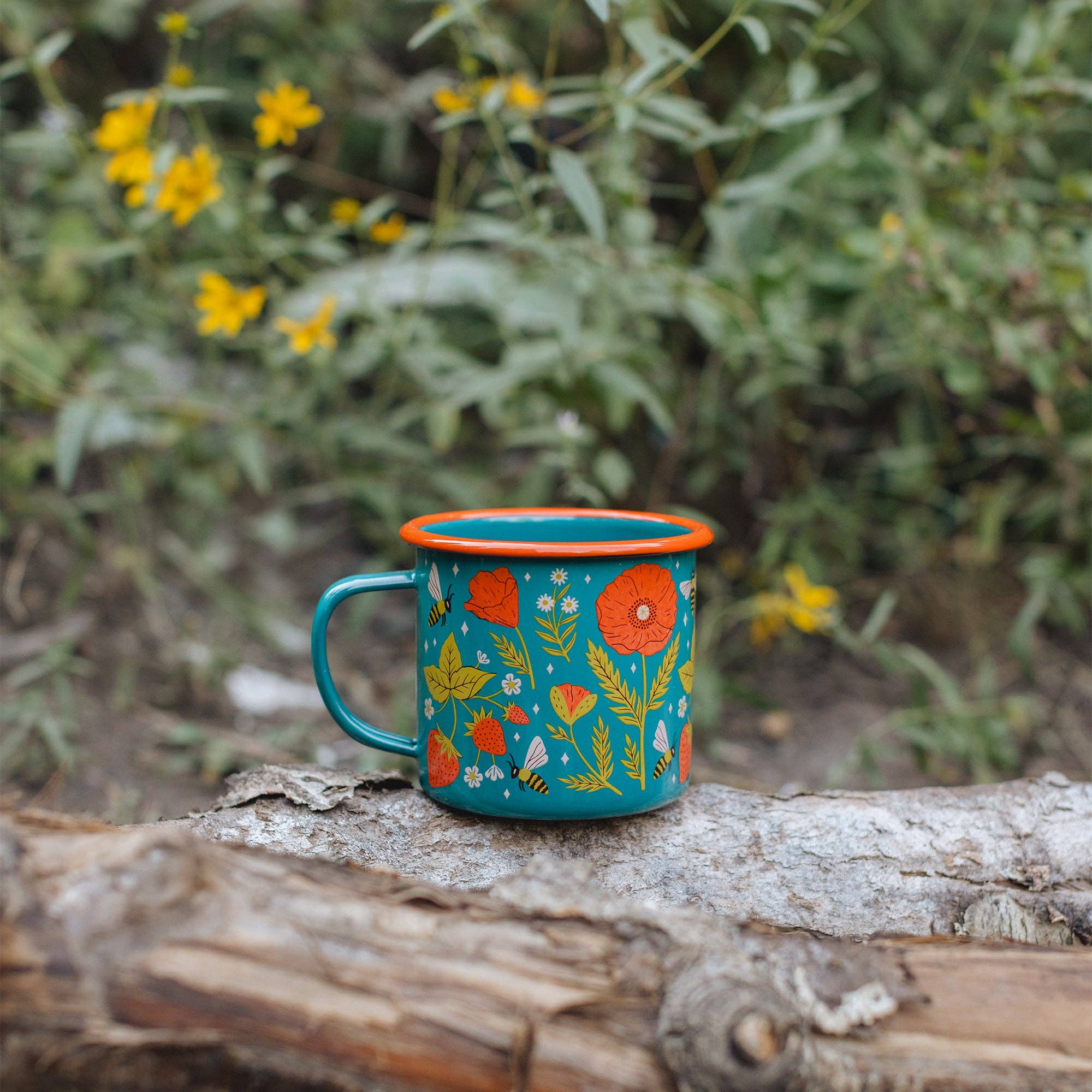 Colorful mug with floral design on a log in a natural setting