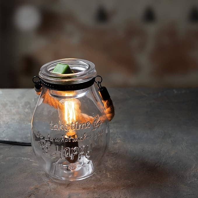 Glass jar with a light bulb inside, featuring an inspirational quote on a blurred background