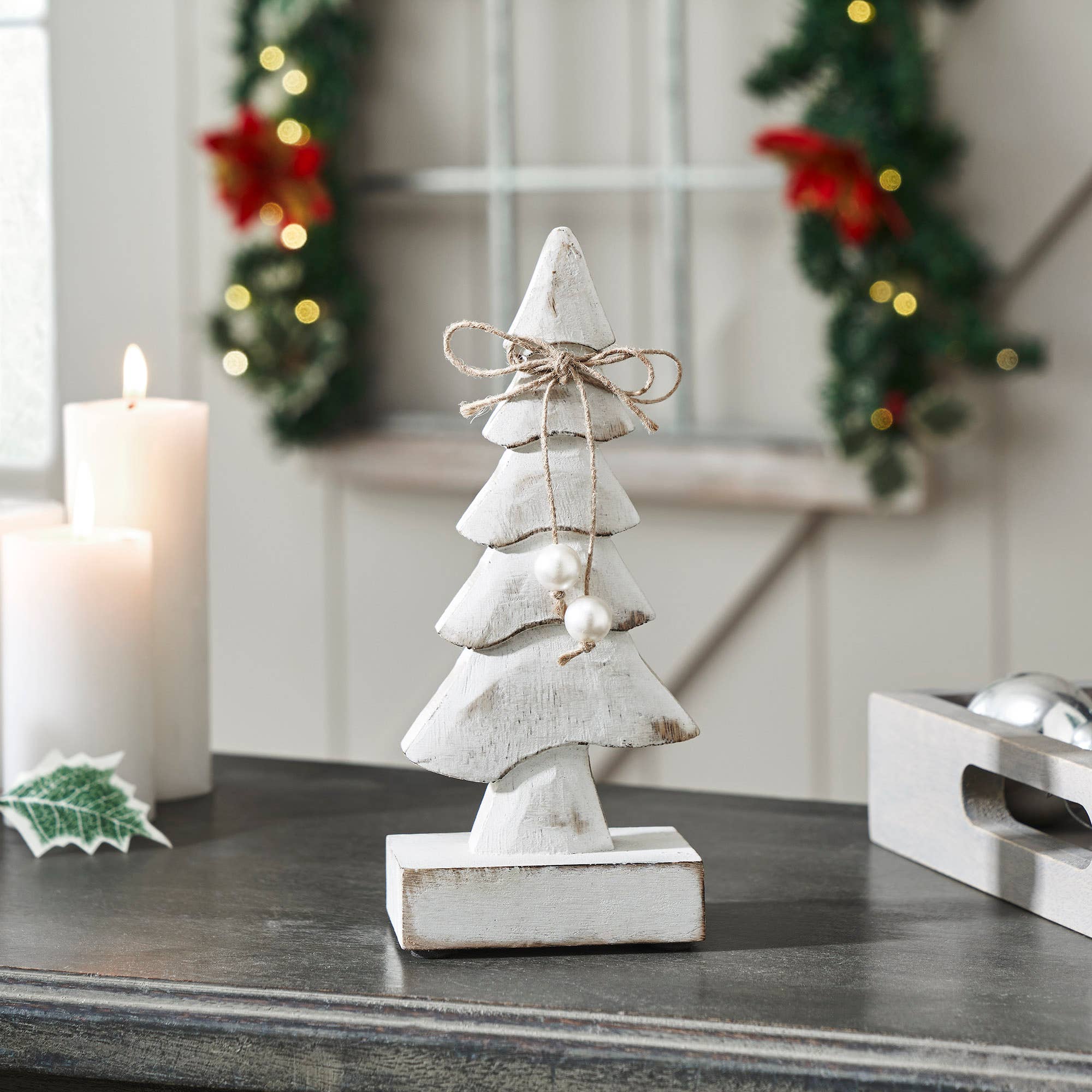 Decorative white Christmas tree figurine on a table with festive background
