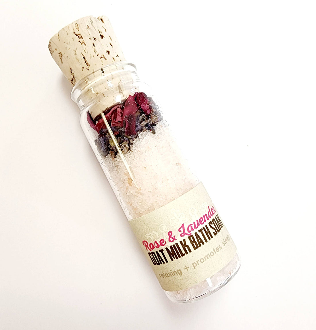 Three glass vials with cork lids, each filled with different bath soak blends. The vials are labeled with different scent combinations such as Milk & Honey and Rose & Lavender.