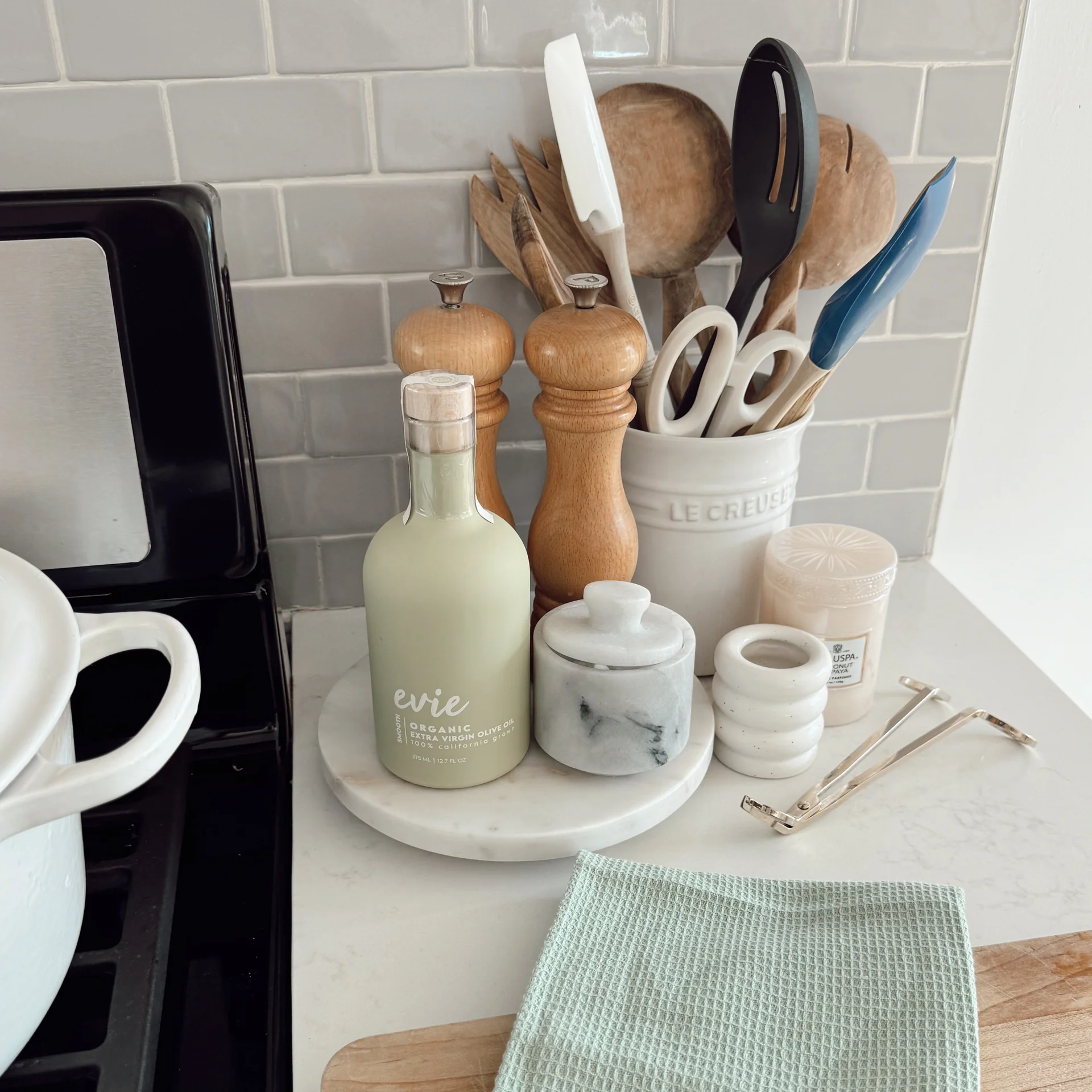 Kitchen counter with utensils, containers, and a bottle labeled &