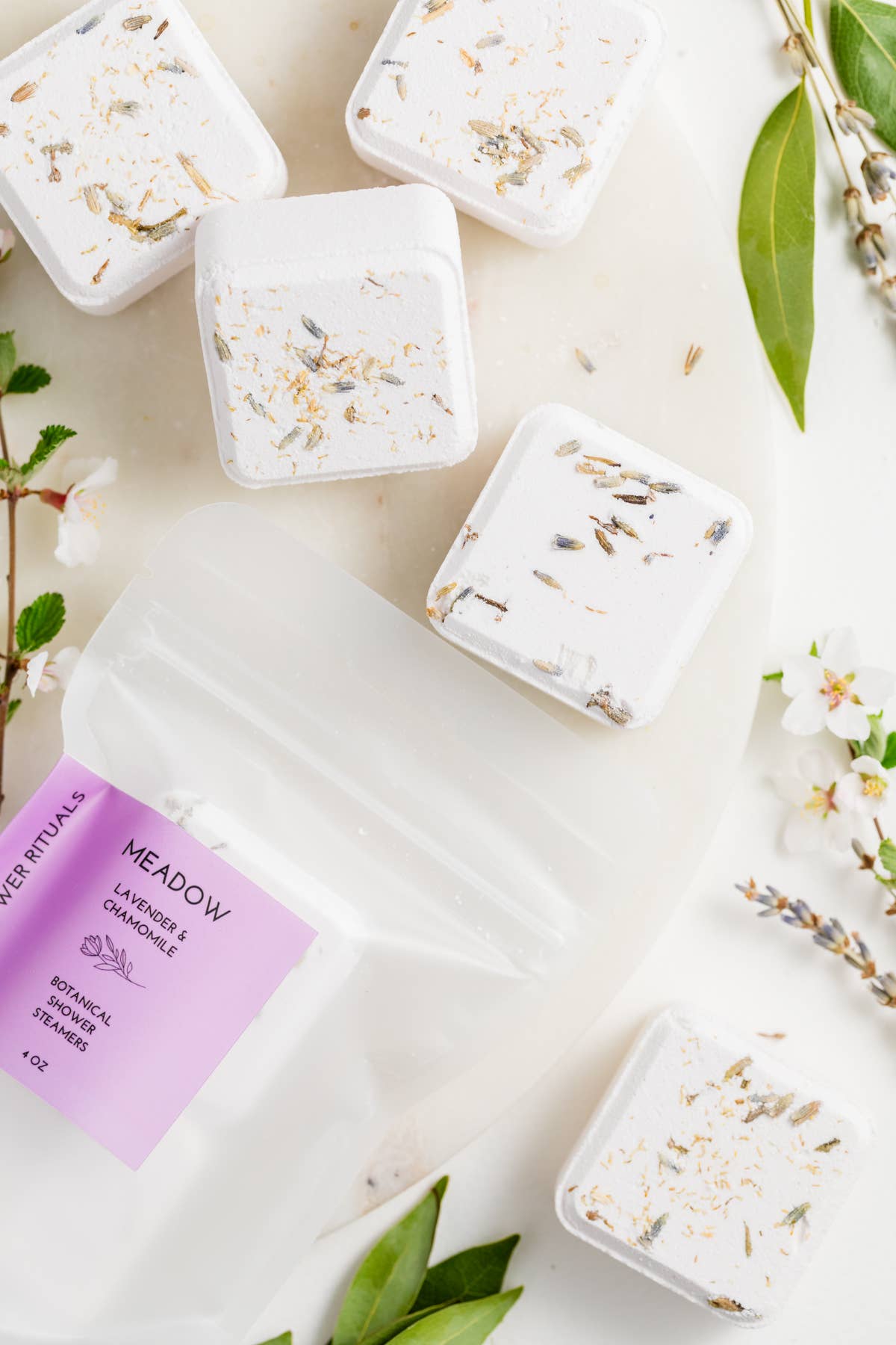 Meadow lavender shower steamers on a white surface with a purple label.