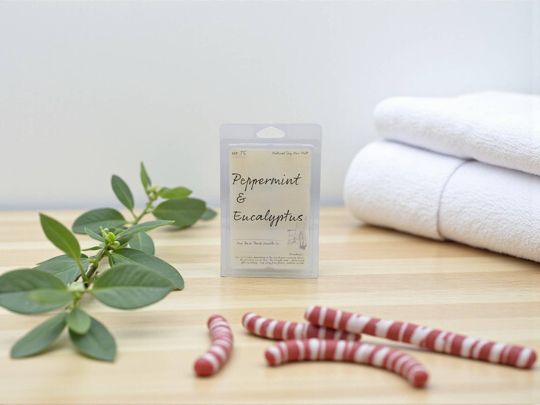 Peppermint and eucalyptus product packaging on a wooden surface with towels and a plant.
