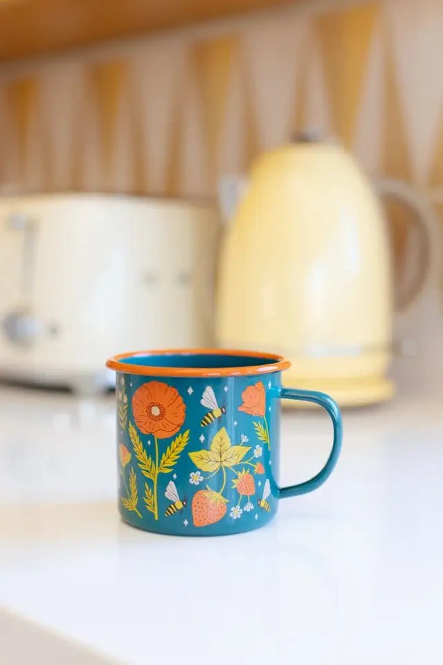 Blue mug with floral design on a kitchen counter with toaster and kettle in the background