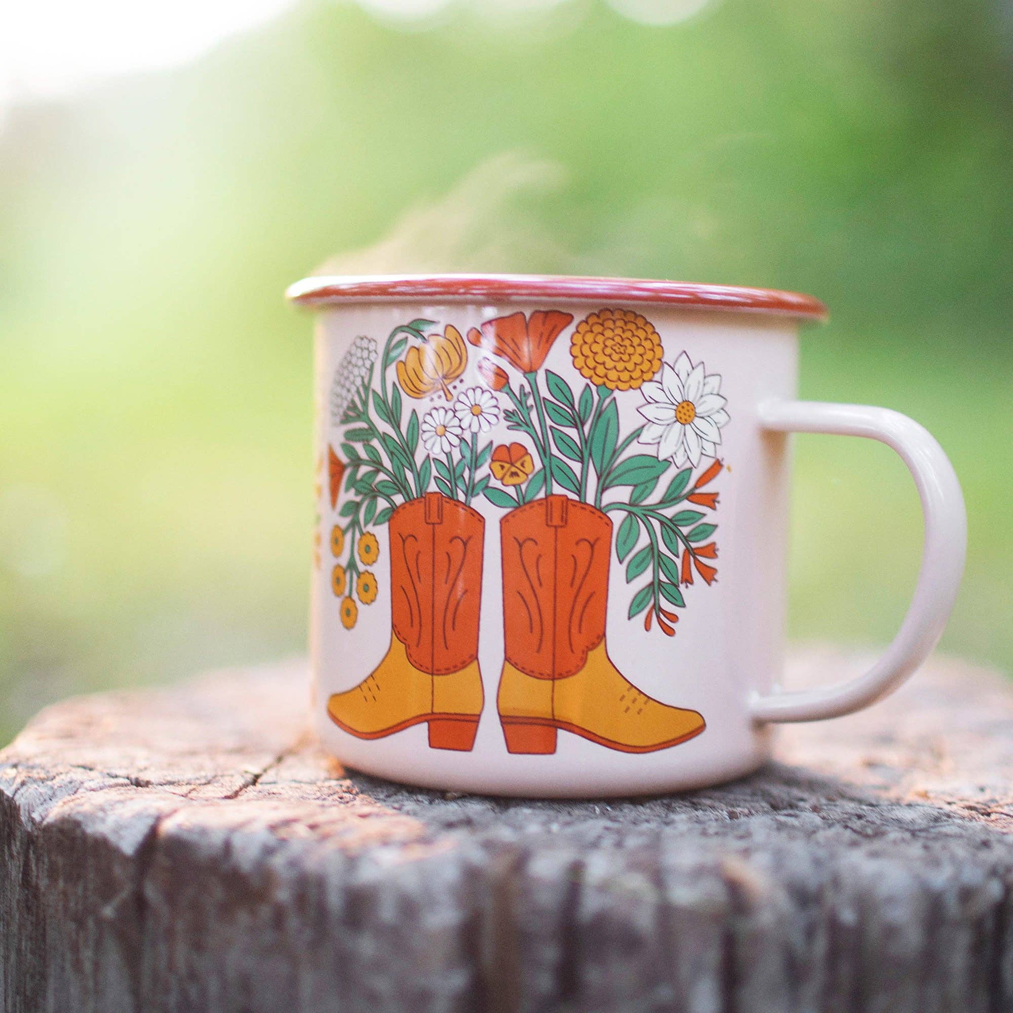 Mug with cowboy boot and floral design on a wooden surface with a blurred green background