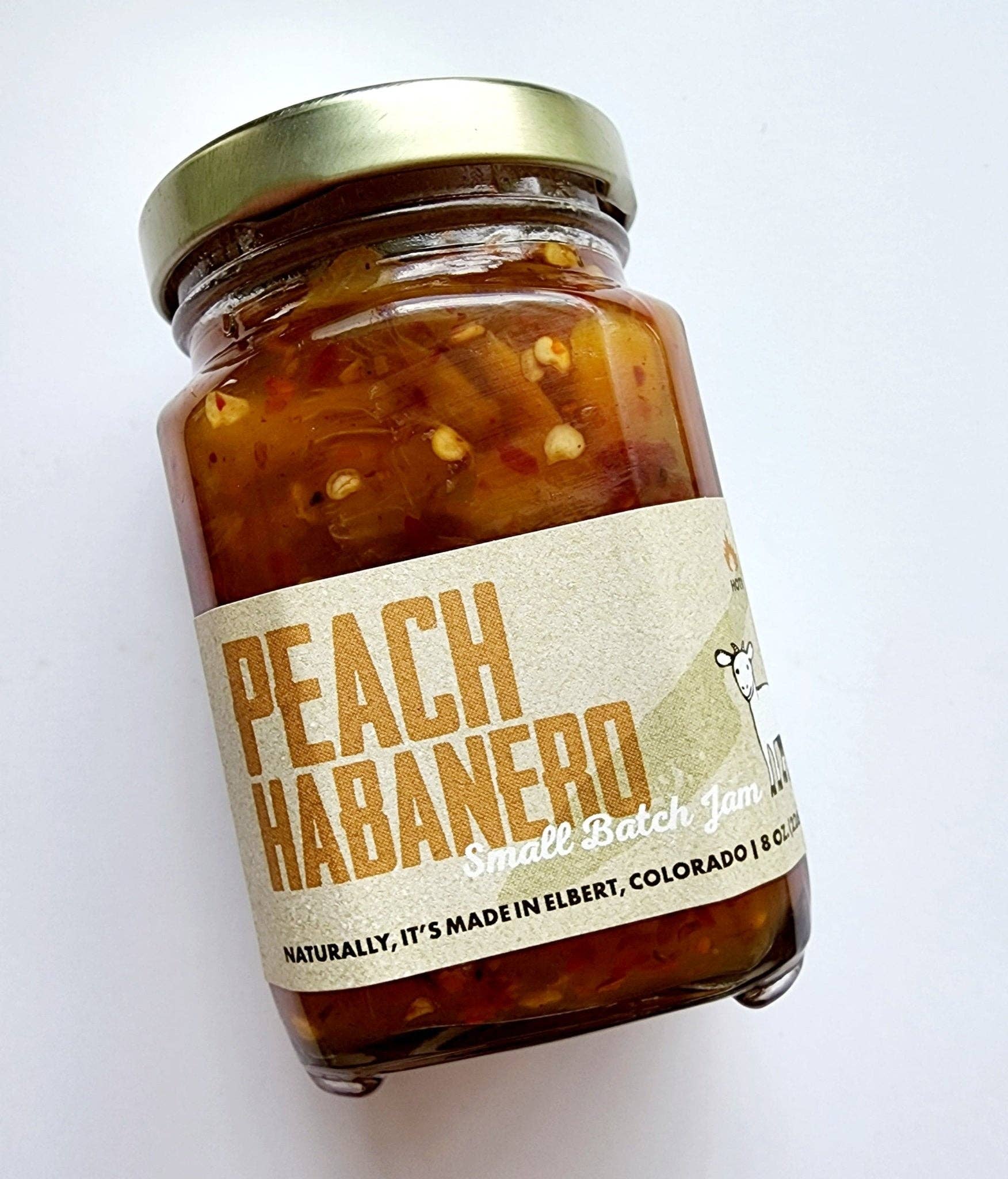 Jar of Peach Habanero jam with a gold lid on a white background