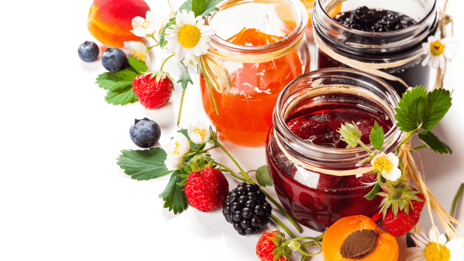 Jams in jars surrounded by fresh berries