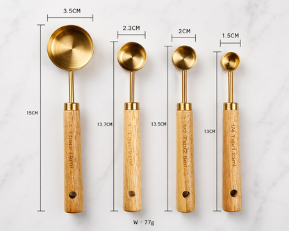 Set of four gold measuring spoons with wooden handles, each labeled with dimensions and weight.