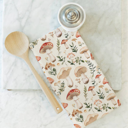 Notebook with mushroom and leaf pattern on a marble surface with a wooden spoon