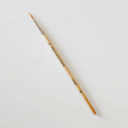 Paintbrush with wooden handle and metal ferrule on a white background