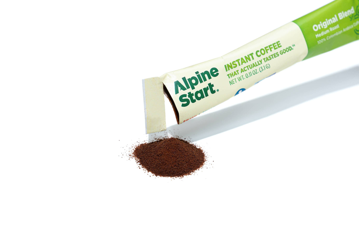 Alpine Start instant coffee stick pack with ground coffee spilling out on a white background