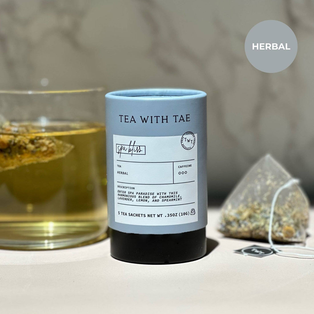 Tea packaging with a glass of tea and loose tea leaves on a blurred background