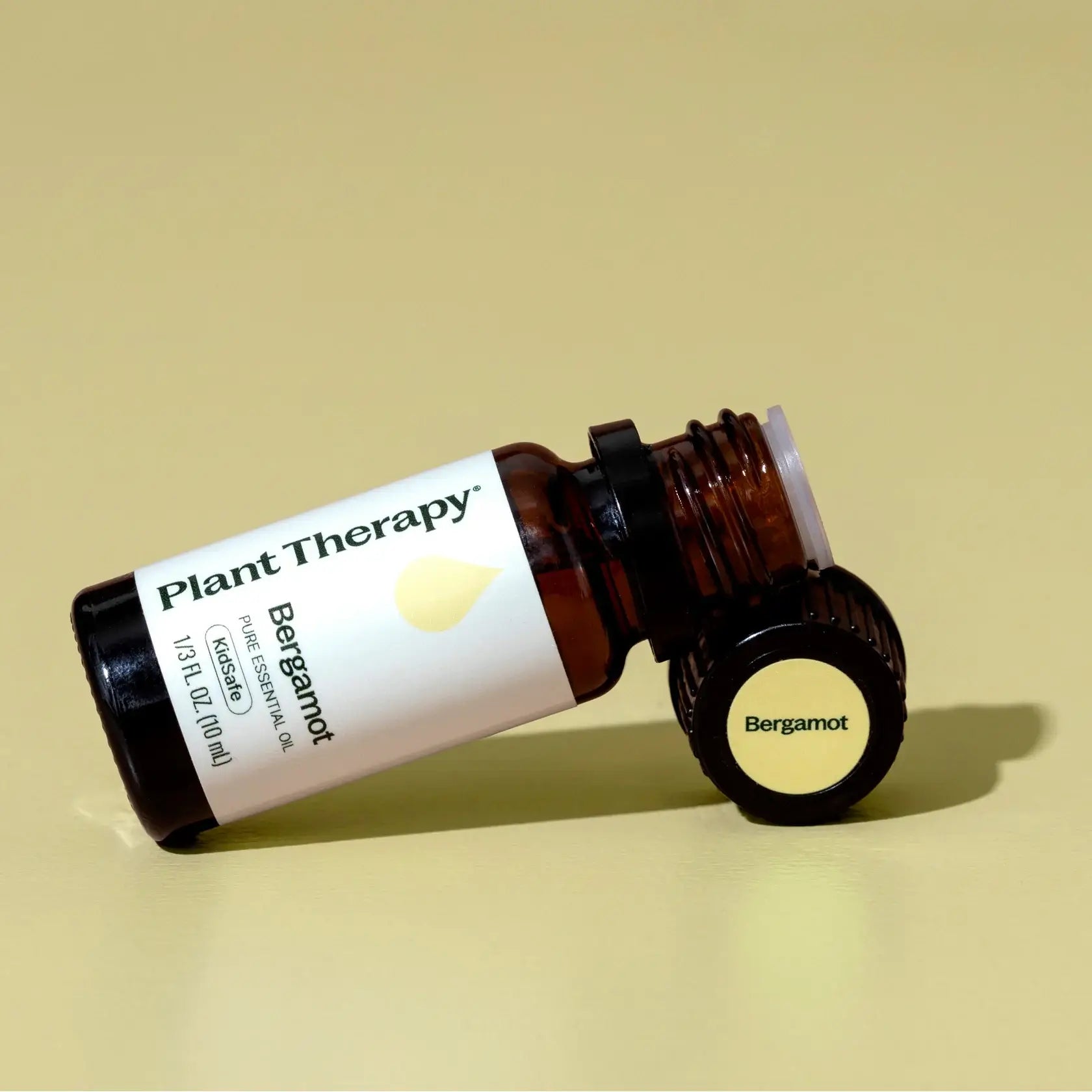 Bottle of Plant Therapy Bergamot essential oil on a beige background