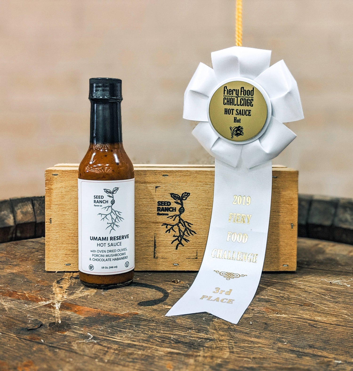 Hot sauce bottle with a ribbon on a wooden surface