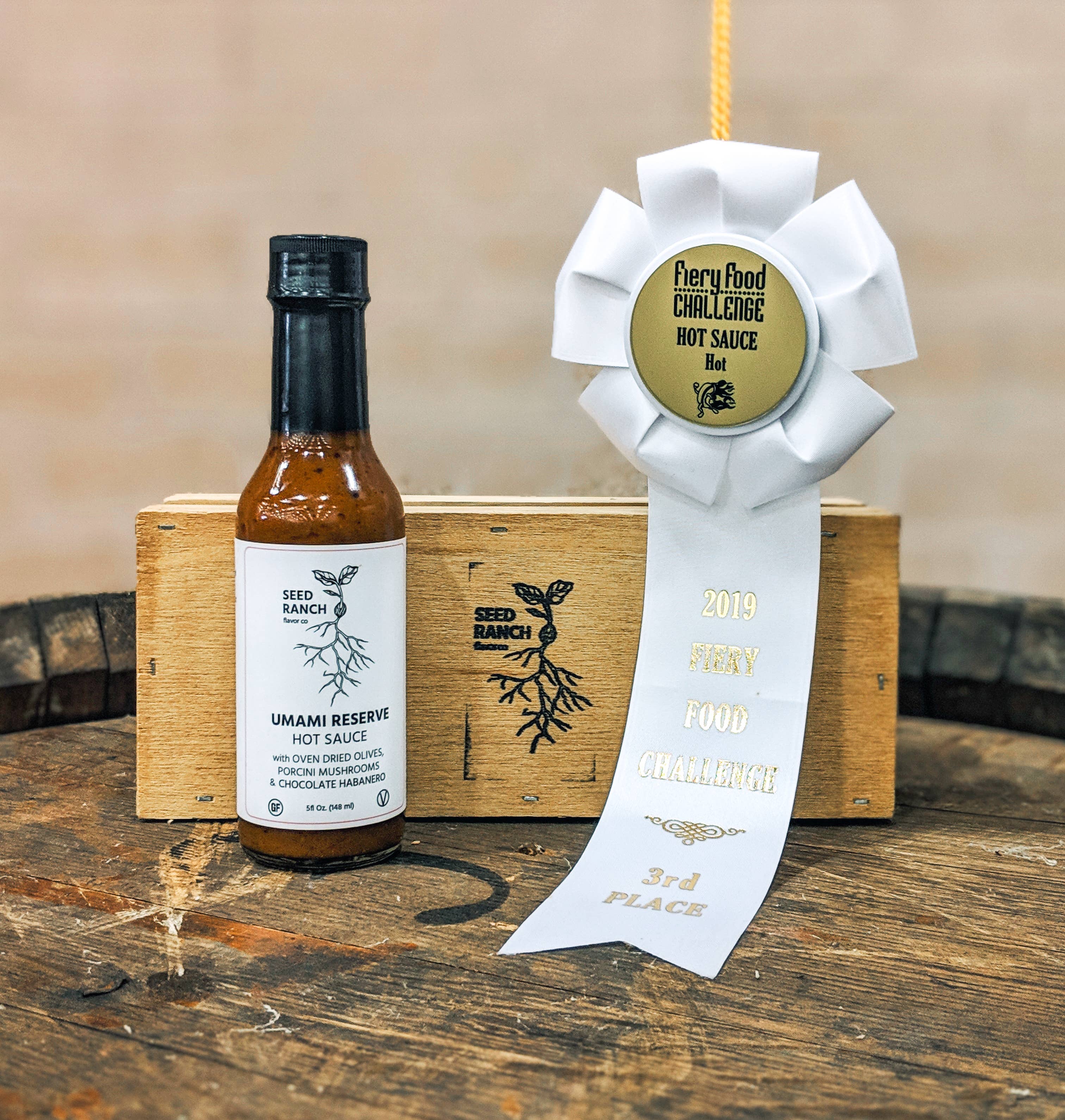 Hot sauce bottle with a ribbon on a wooden surface