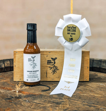 Hot sauce bottle with a ribbon on a wooden surface