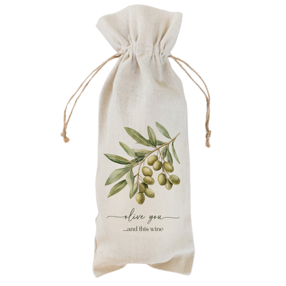 A natural beige linen wine bag with a drawstring closure, featuring a printed illustration of green olives on an olive branch and the text &