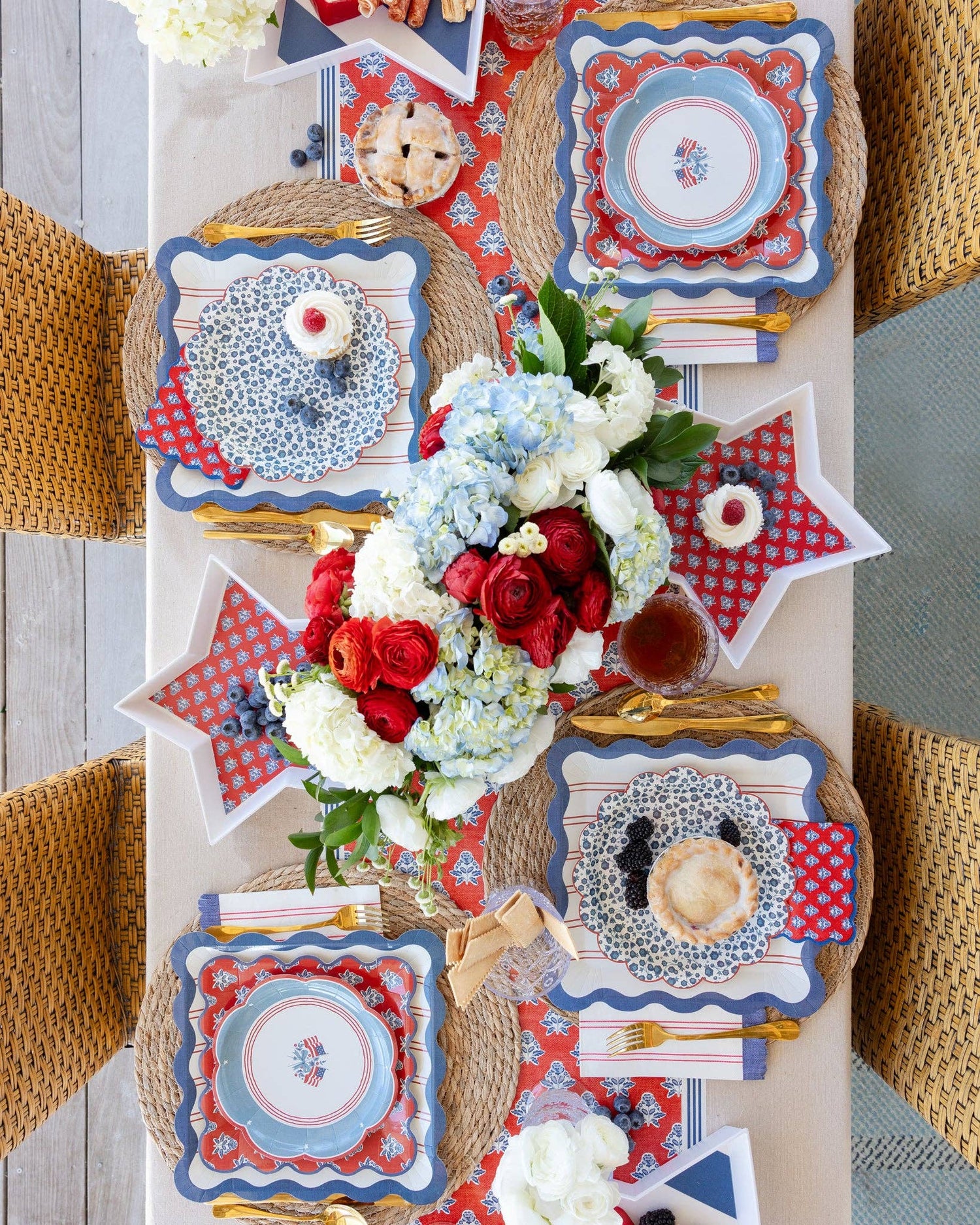 Decorative table setting with red, white, and blue plates and flowers.