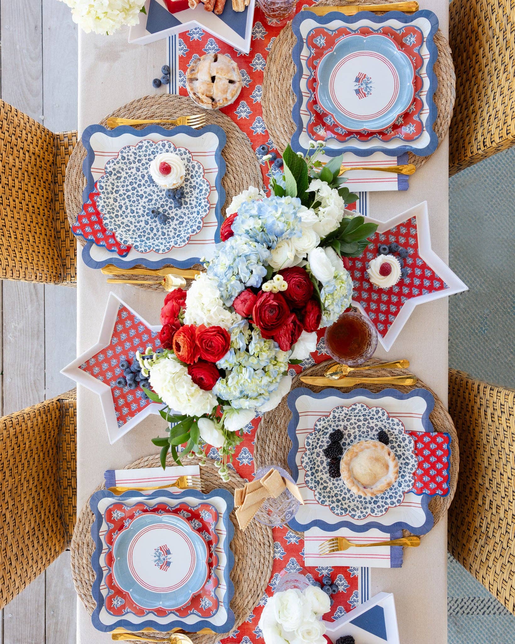 Decorative table setting with red, white, and blue plates and flowers.