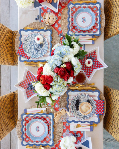 Decorative table setting with red, white, and blue plates and flowers.