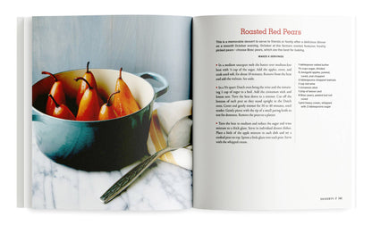 Open book showing a recipe for roasted red pears with an image of pears in a bowl.
