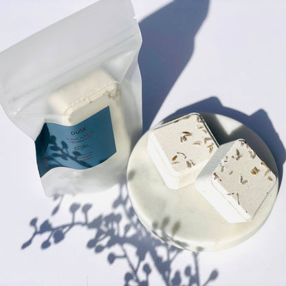 White shower steamers with floral elements on a white surface