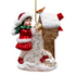 Christmas ornament of a girl in red dress and Santa hat with a rabbit, on a white background