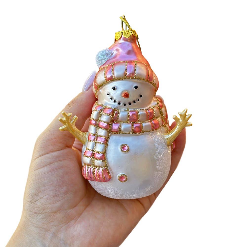 Decorative snowman ornament held in a hand against a white background