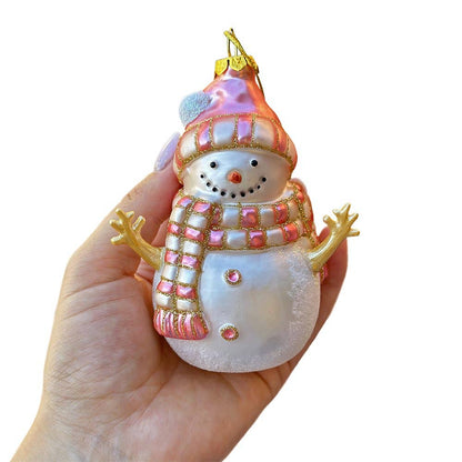 Decorative snowman ornament held in a hand against a white background