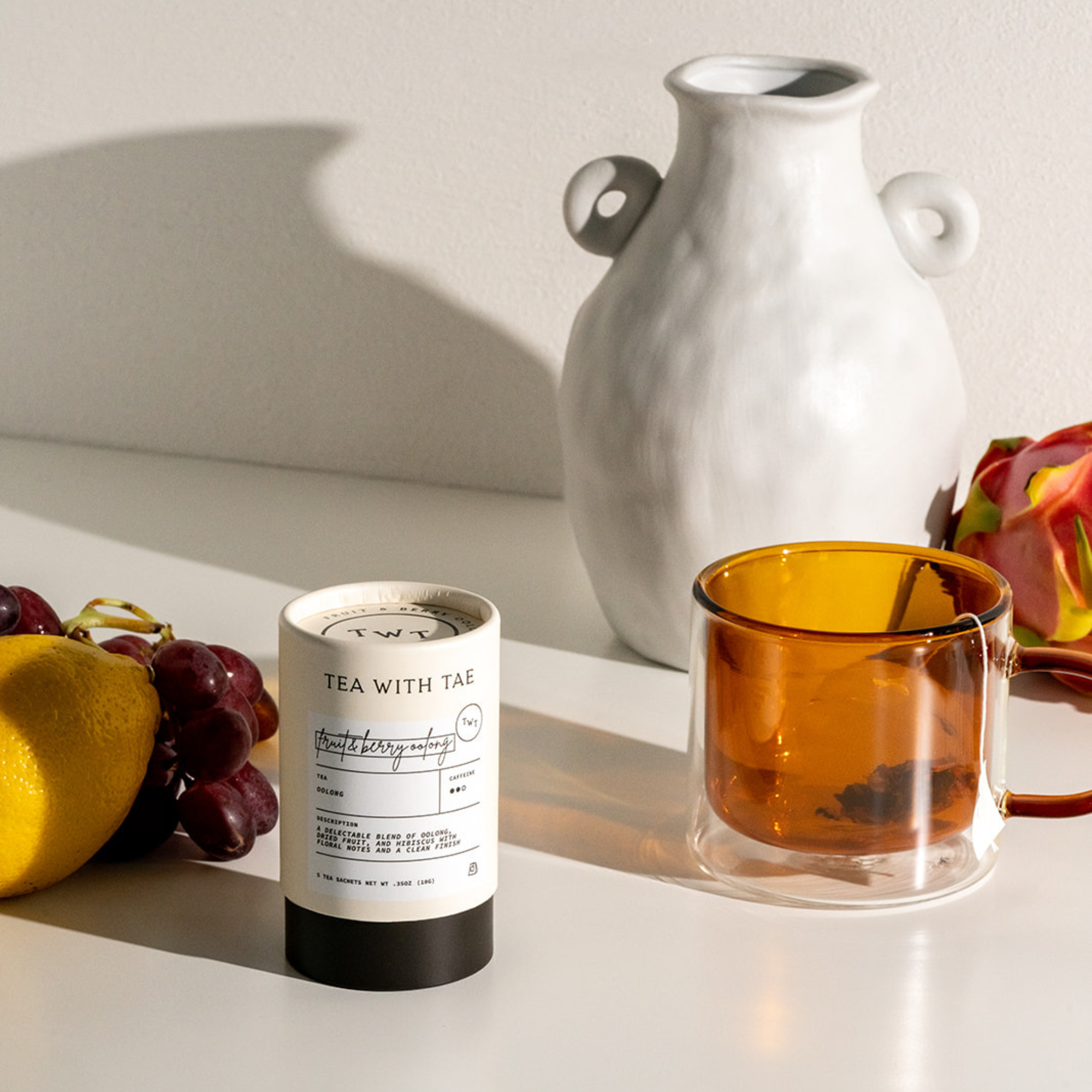 Tea packaging with a cup of tea and fruits on a light surface