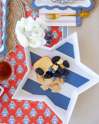 Star-shaped bamboo tray with fruit and cheese on a patterned tablecloth