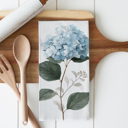 Kitchen towel with floral design on a wooden cutting board with utensils