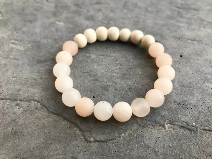 Beaded bracelet with pink beads on a gray surface