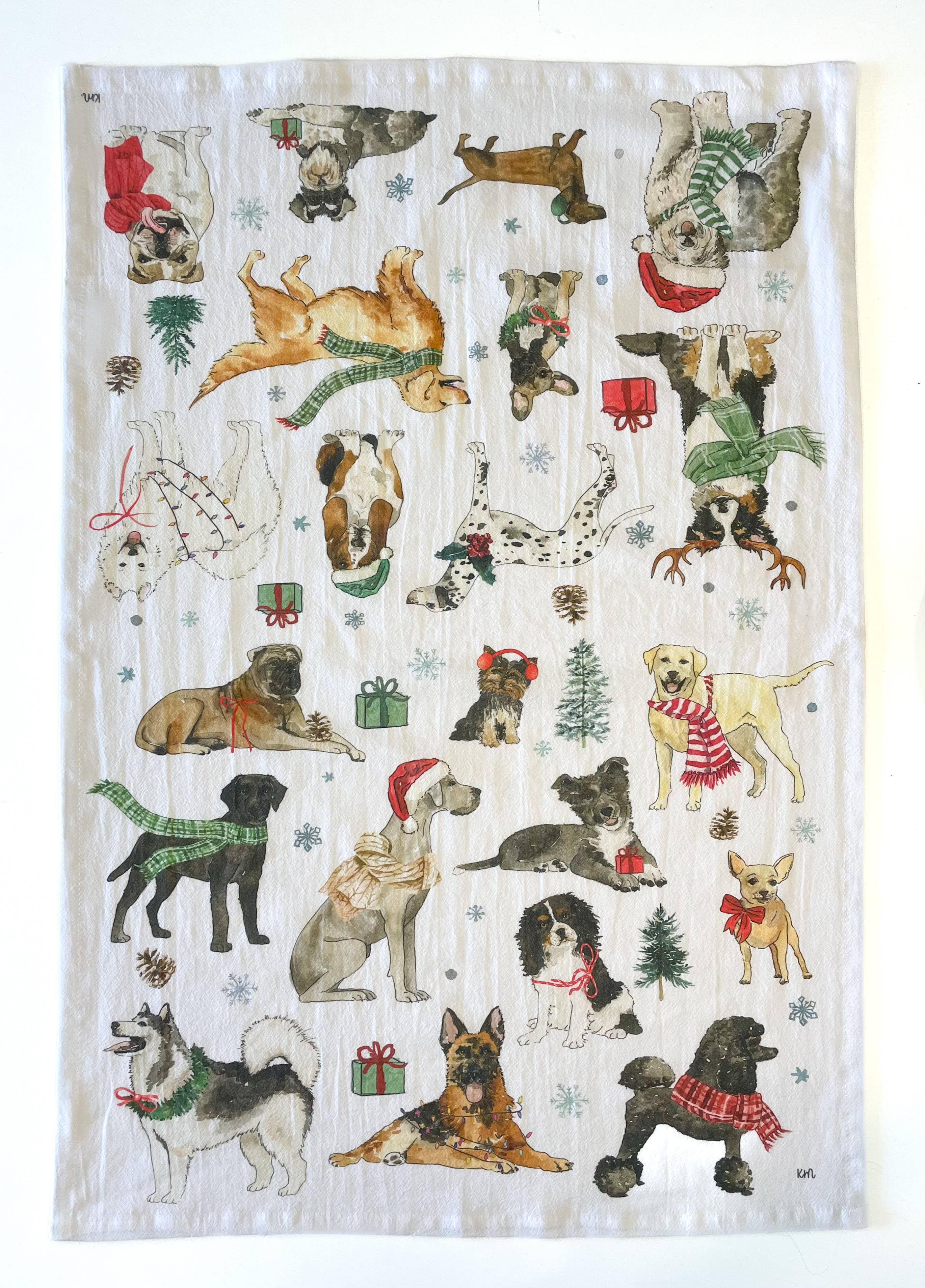 Tea towel with Christmas-themed dogs wearing scarves and hats on a white background