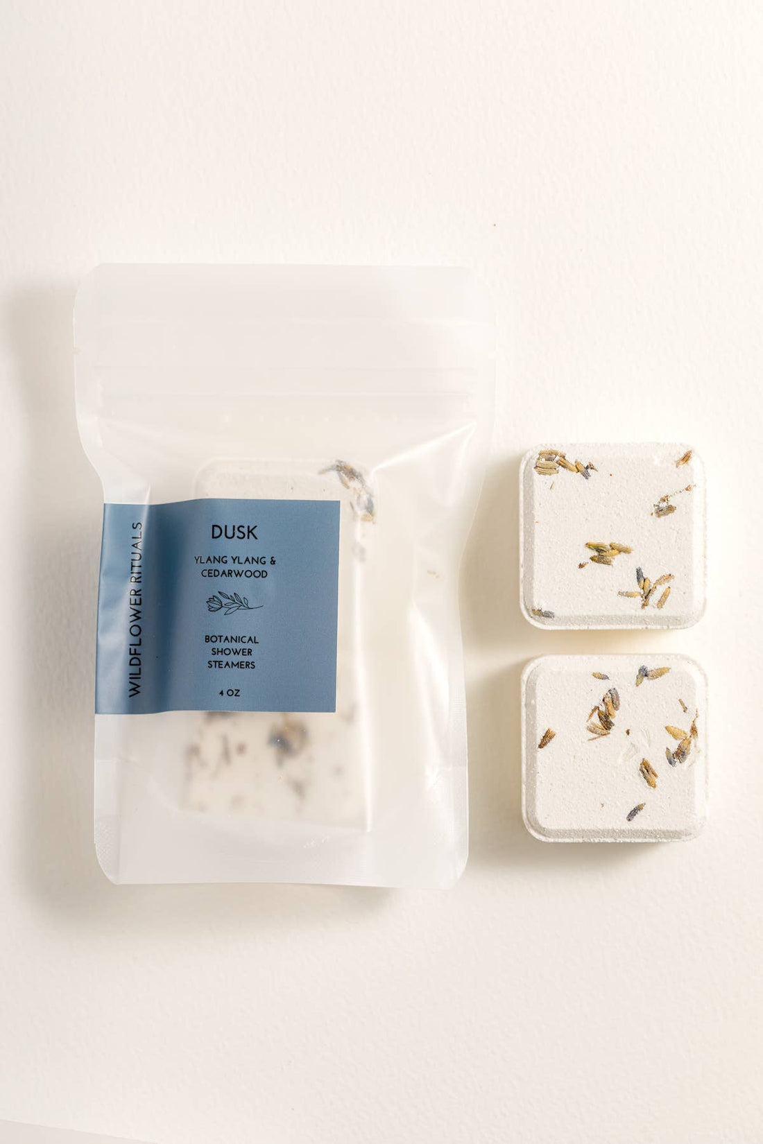 Packaged shower steamers with a blue label on a white background