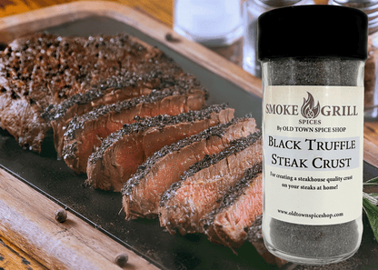 Sliced steak with a jar of Smoke &amp; Grill Spices Black Truffle Steak Crust on a wooden cutting board.