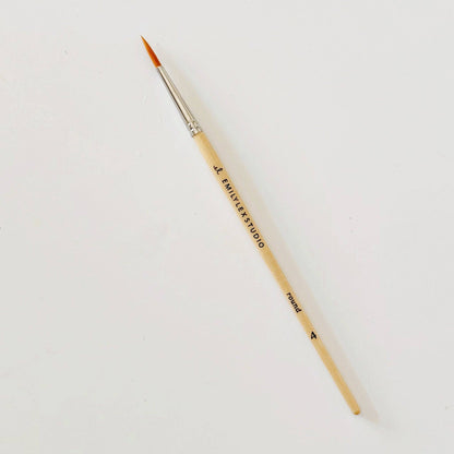 Paintbrush with wooden handle and metal ferrule on a white background