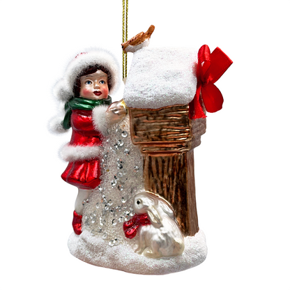 Christmas ornament of a girl with a rabbit and snow-covered house on a white background