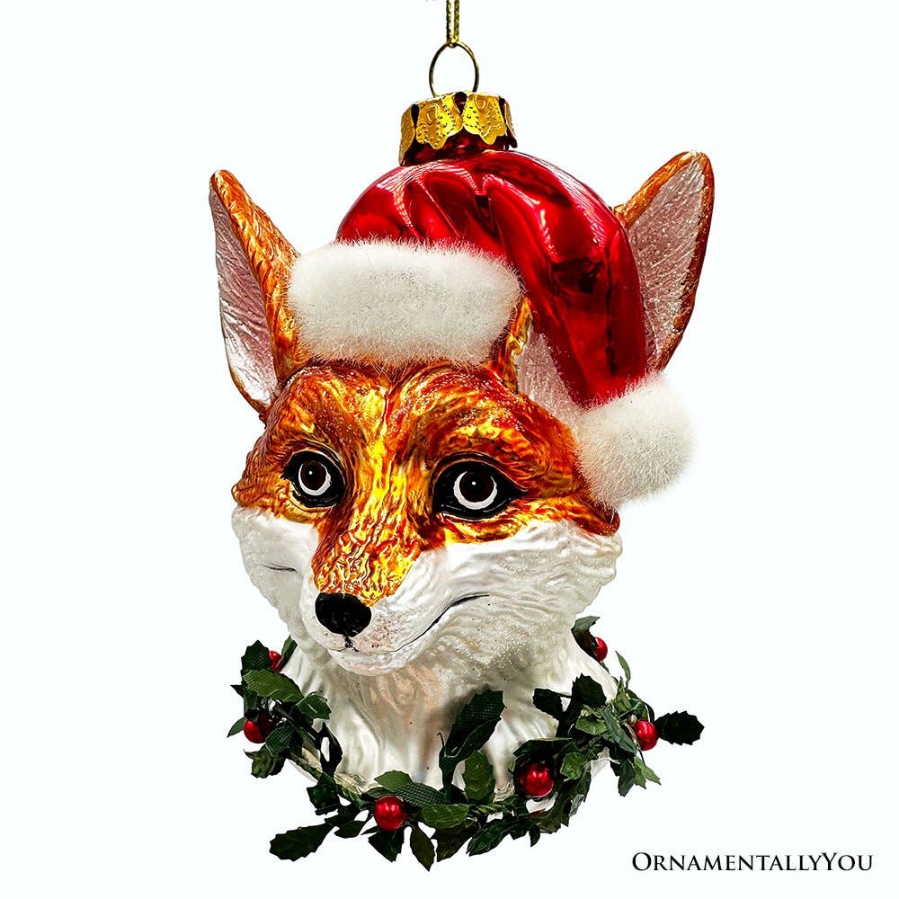 Christmas ornament shaped like a fox head with a Santa hat and holly leaves on a white background.