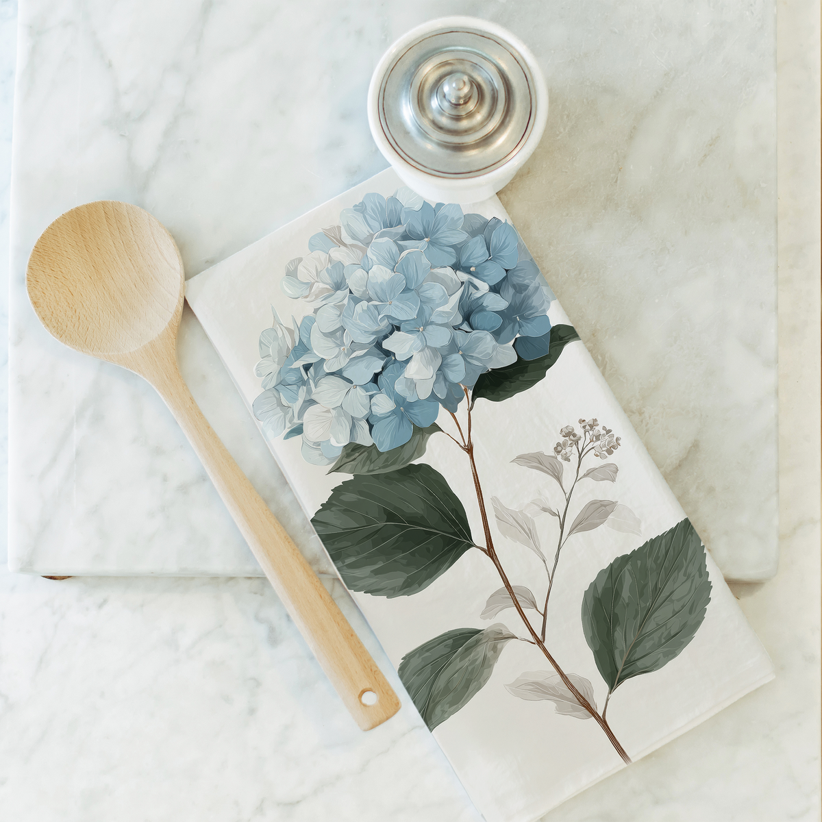 Notebook with floral design on a marble surface with a wooden spoon and small container.